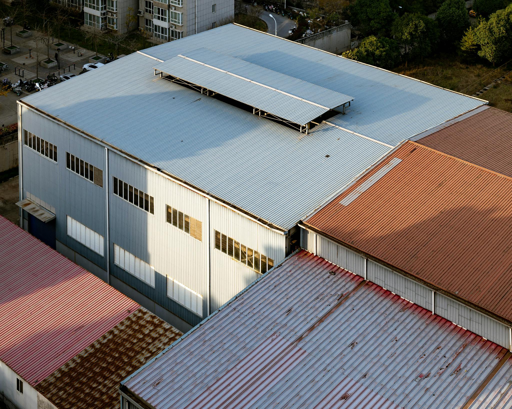Aerial shot showcasing industrial building roofs with varying colors in Luoyang, China.